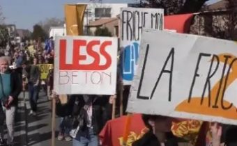 Photo manifestants lors de la Marche festive aux Pradettes pour le projet de ferme urbaine. Pancartes "Less Béton", "La friche"
